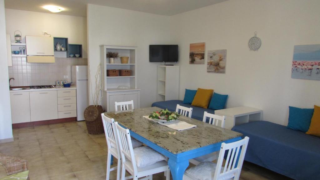 a kitchen and living room with a table and a blue couch at FLAMINGO in Lesina