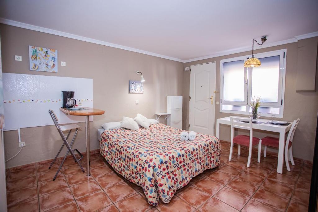 a bedroom with a bed and a table and a desk at Beachback Studio Apt Low-cost nearby Airport in La Garita