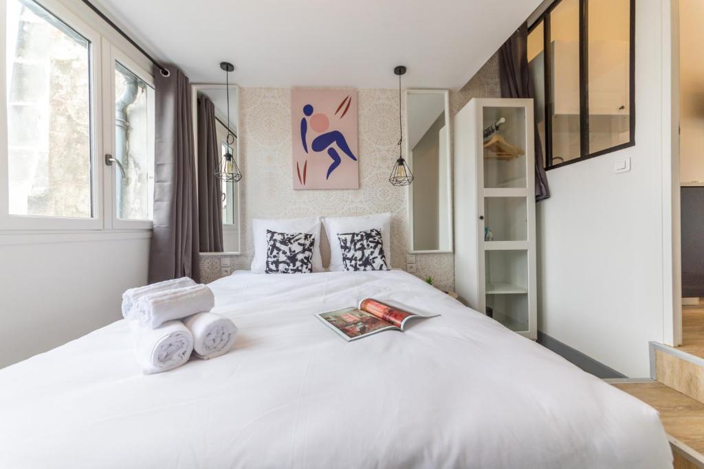 a bedroom with a white bed with towels on it at Apartments WS Saint-Lazare - Lafayette in Paris