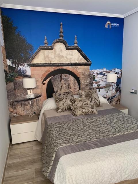 a bedroom with a large bed with a stone wall at Apartamento Felipe V in Ronda