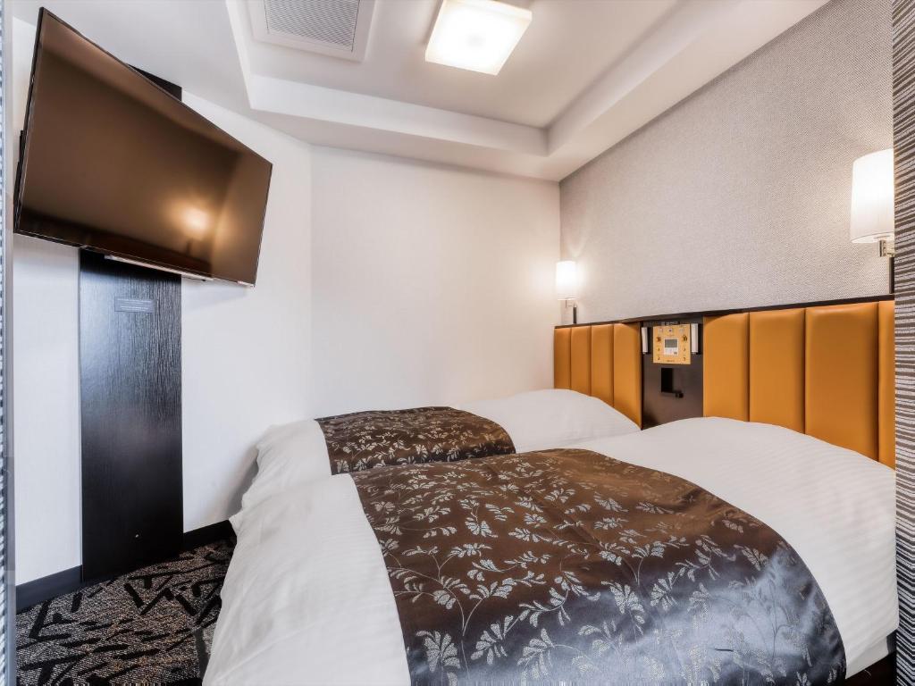 Postel nebo postele na pokoji v ubytování APA Hotel Takaoka Ekimae