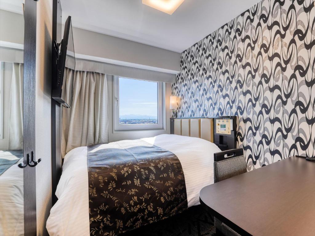 Postel nebo postele na pokoji v ubytování APA Hotel Takaoka Ekimae