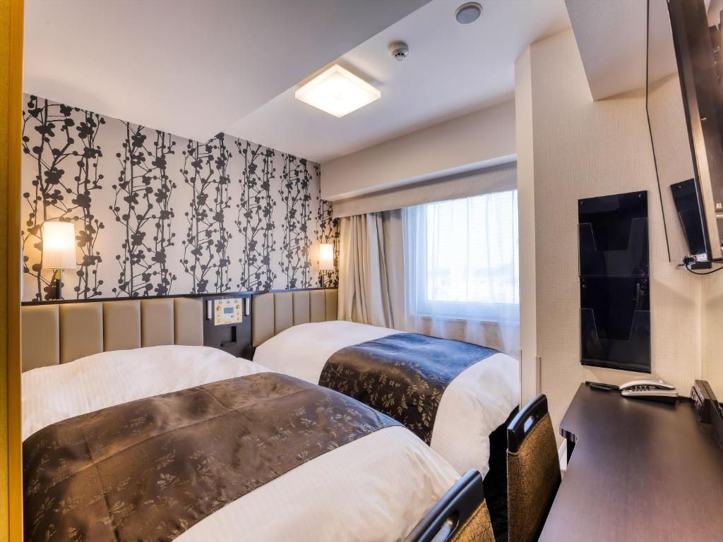Postel nebo postele na pokoji v ubytování APA Hotel Takaoka Ekimae