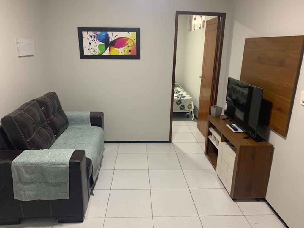ein Wohnzimmer mit Couch und Flachbildfernseher in der Unterkunft Pousada Residencial Milagre 101 in Juazeiro do Norte