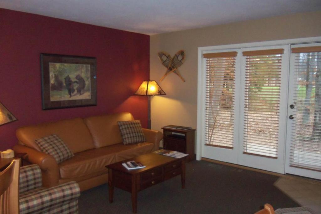uma sala de estar com um sofá e uma mesa em Wintergreen Condos em Thompsonville