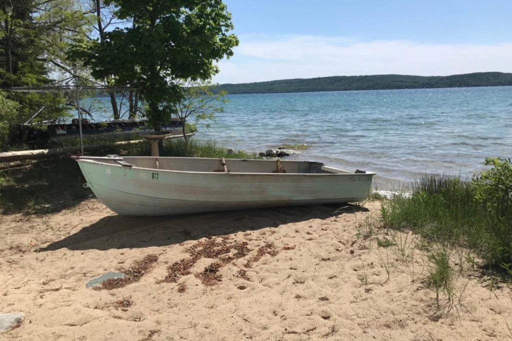 a boat sitting on the beach next to the water at Grandma's Sandbox in Beulah