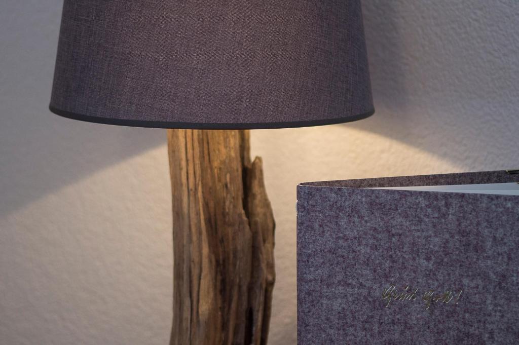 a wooden lamp with a shade on a table at Fürmesli Appartements in Lech am Arlberg