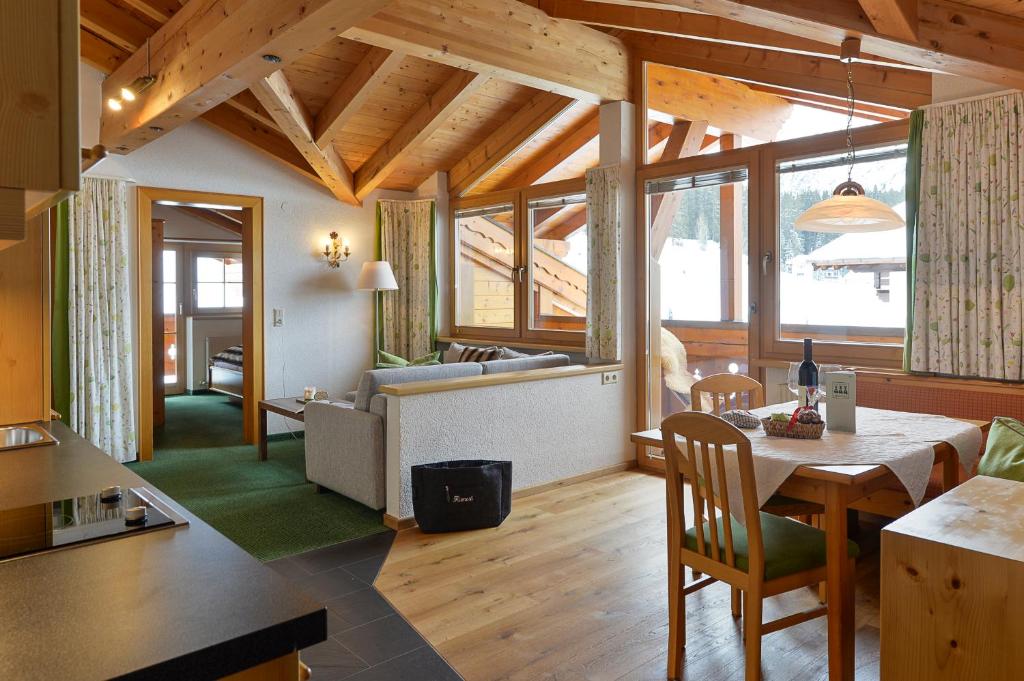 a kitchen and living room with a table and chairs at Fürmesli Appartements in Lech am Arlberg