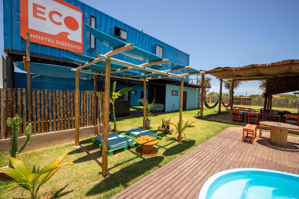 eine Terrasse mit Whirlpool und ein Gebäude in der Unterkunft Eco Hostel & Suítes in São Miguel do Gostoso