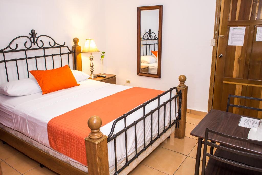 a bedroom with a bed and a table at Hotel Verona in San Pedro Sula