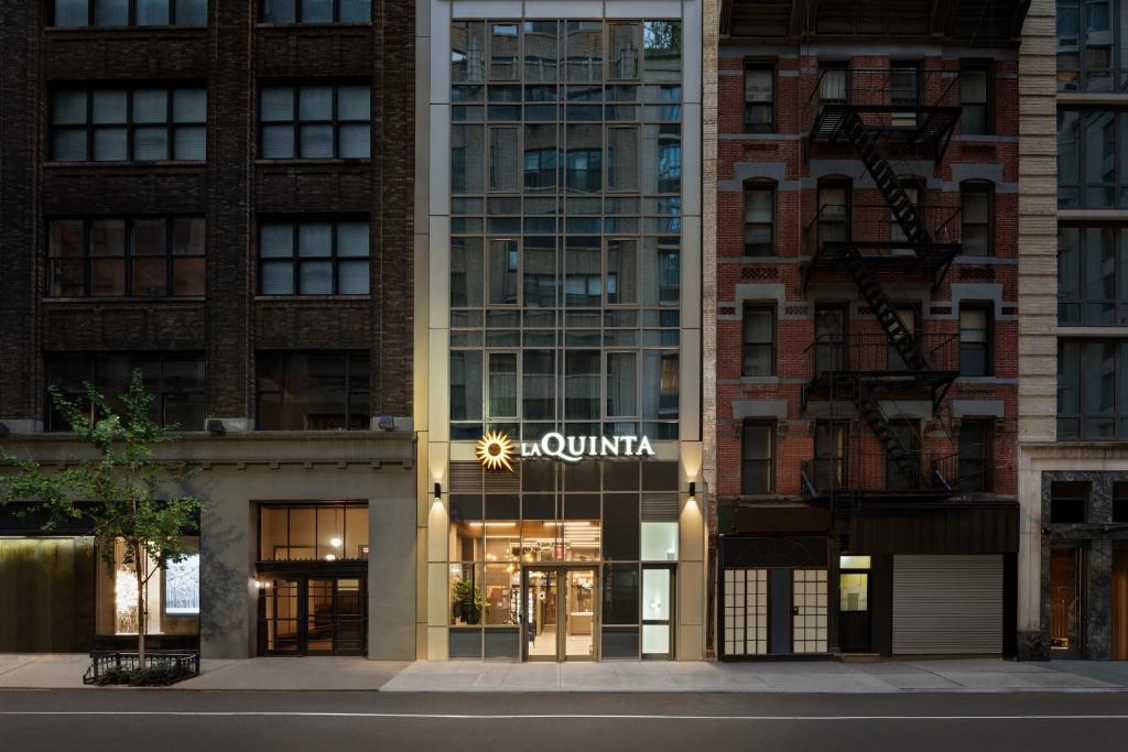 a building with aania sign on the front of it at La Quinta by Wyndham Time Square South in New York