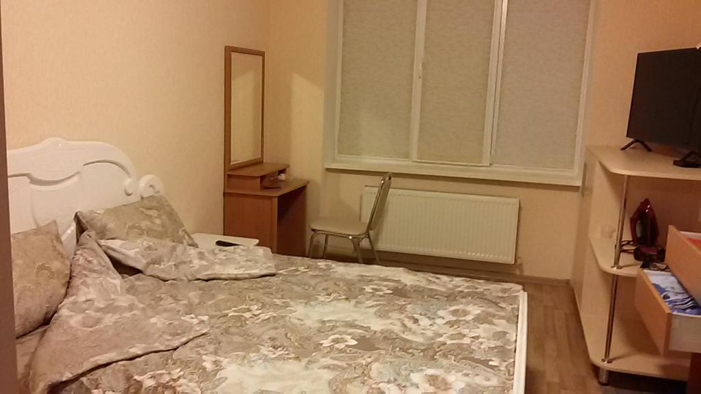 a bedroom with a bed and a window and a television at Wine Casual Apartment in Chişinău