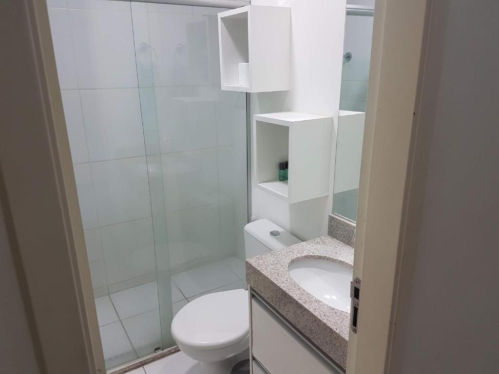 uma casa de banho com um WC e uma cabina de duche em vidro. em Flat mobiliado em região nobre de Goiânia em Goiânia