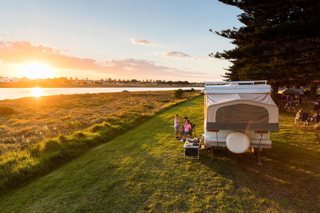 a couple of people standing next to a camper at Gardens Caravan Park in Port Fairy