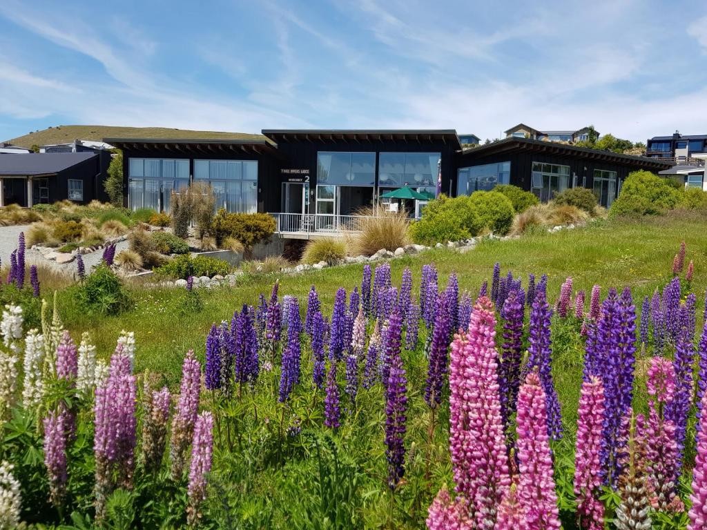 a field of flowers in front of a building at Three Rivers Lodge in Lake Tekapo