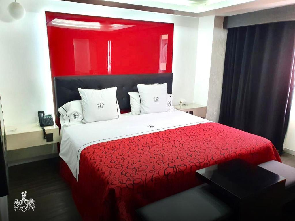 een slaapkamer met een rood bed met een rood hoofdeinde bij Hotel Del Valle in Mexico-Stad