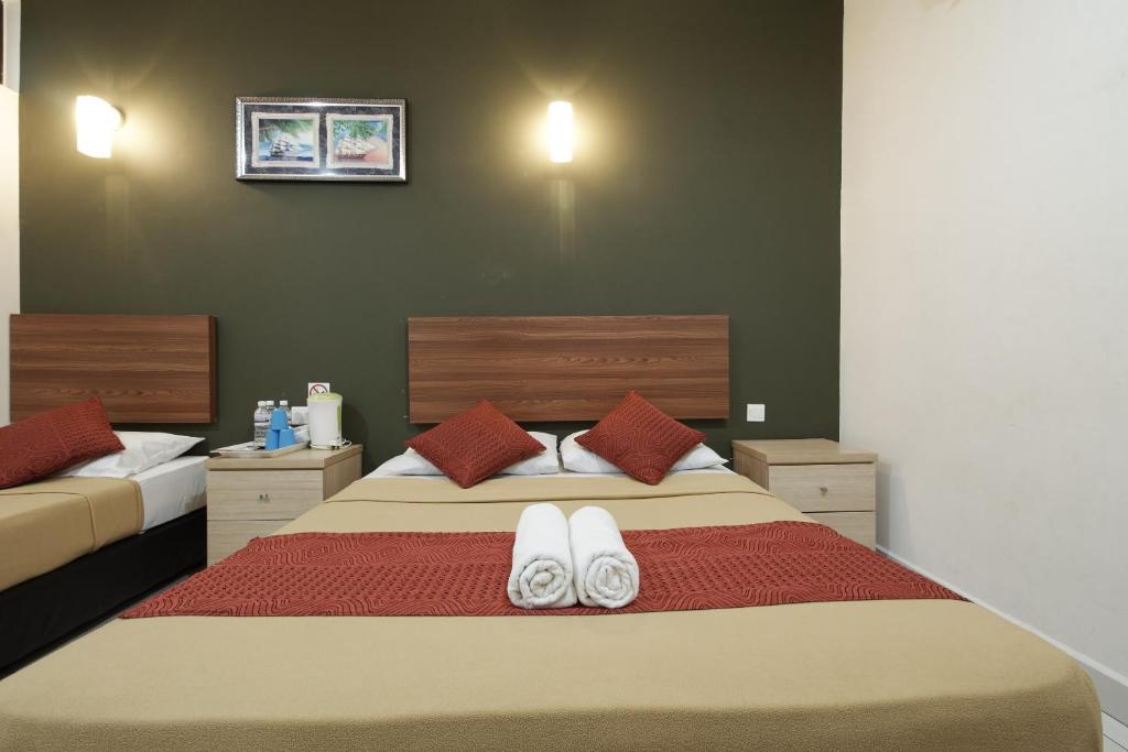 a bedroom with a large bed with white towels on it at COOP HOTEL PUTRAJAYA & CYBERJAYA in Kampung Dengkil