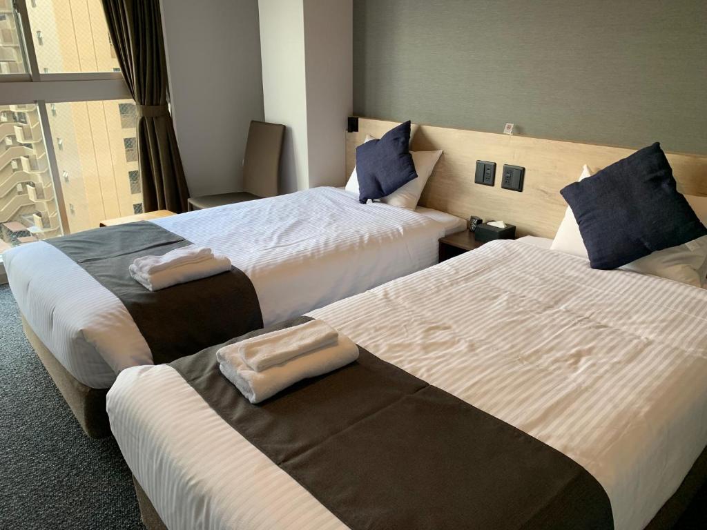 Postel nebo postele na pokoji v ubytování HOTEL STATE TENNOJI