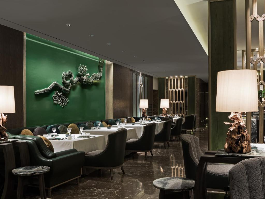 a restaurant with tables and chairs and a green wall at Four Seasons Hotel Seoul in Seoul