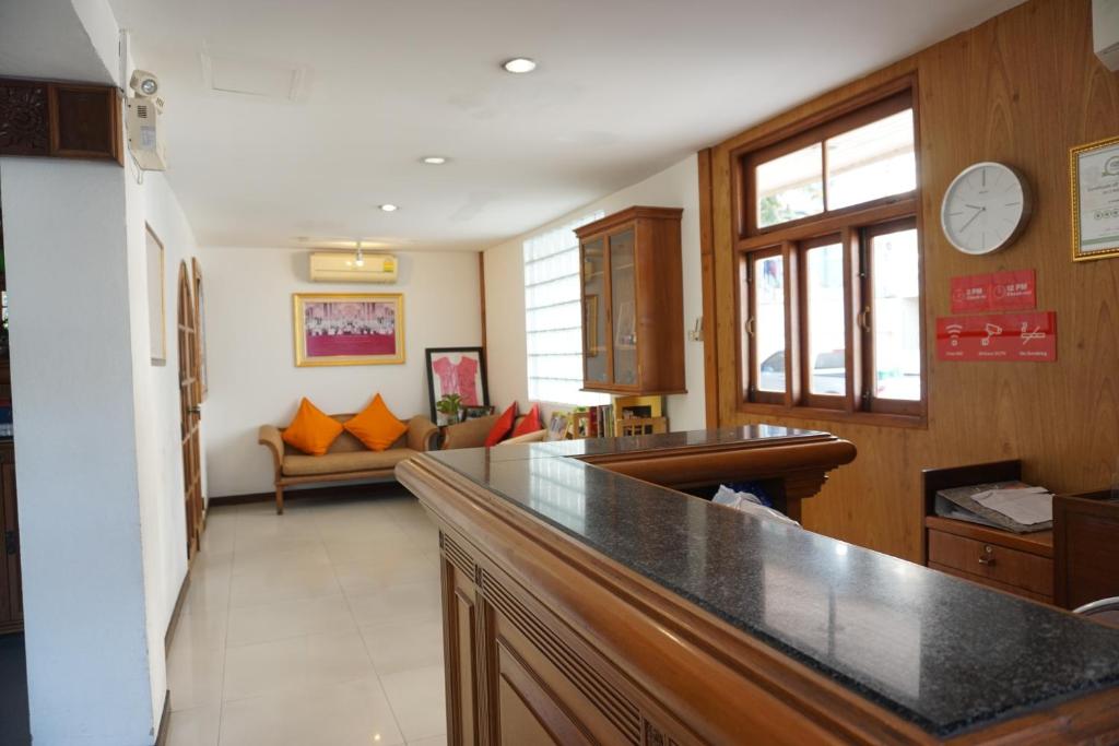 A reception counter overlooking a small lounge with bright orange cushions.