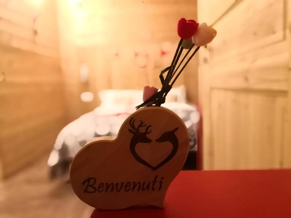 un jarrón con forma de corazón con flores en una mesa en B&B La Locanda del Colle e ristorante, en Limone Piemonte