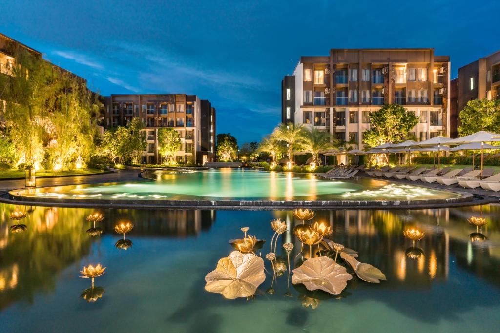 a pool in the middle of a city at night at Divalux Resort & Spa Bangkok, Suvarnabhumi Airport-Free Shuttle in Lat Krabang