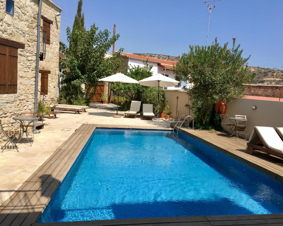 a swimming pool in a yard next to a building at Evkarpos Country House in Psematismenos