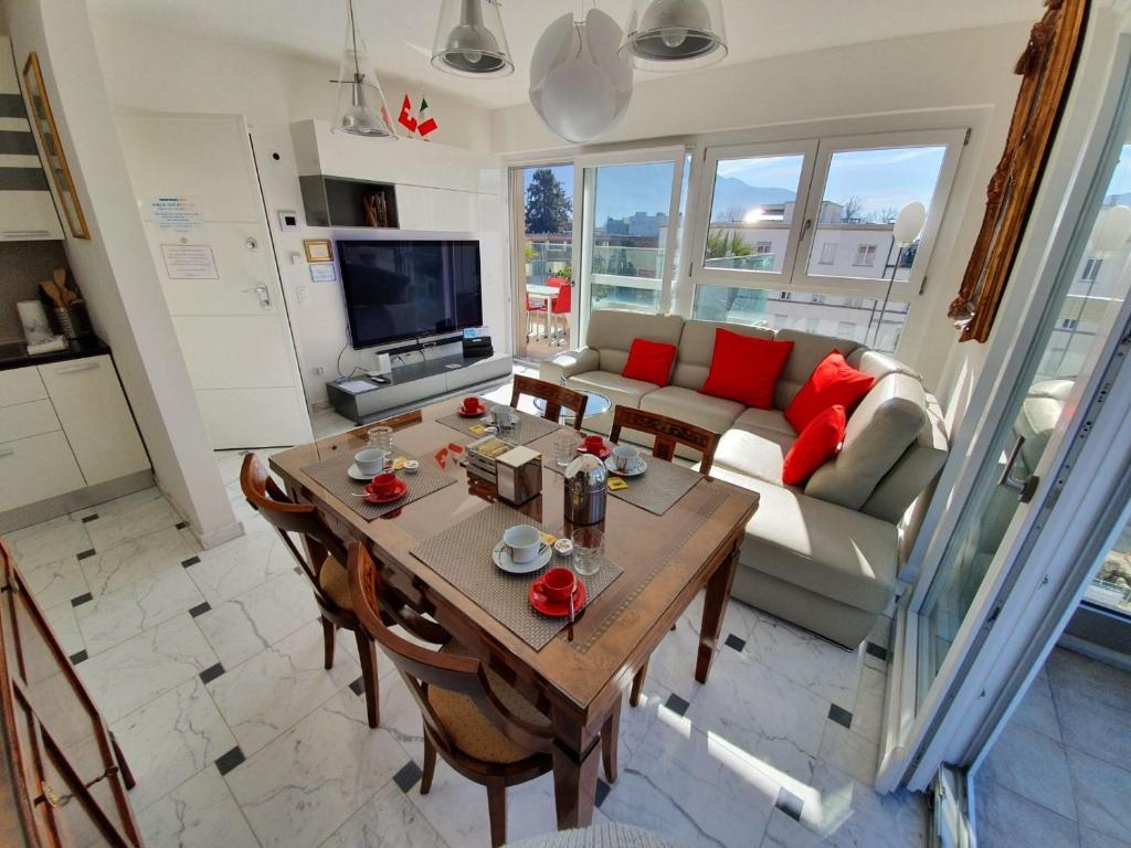 ein Wohnzimmer mit einem Tisch und einem Sofa in der Unterkunft Il Parco 2 by Quokka 360 - cosy flat with terrace in Lugano
