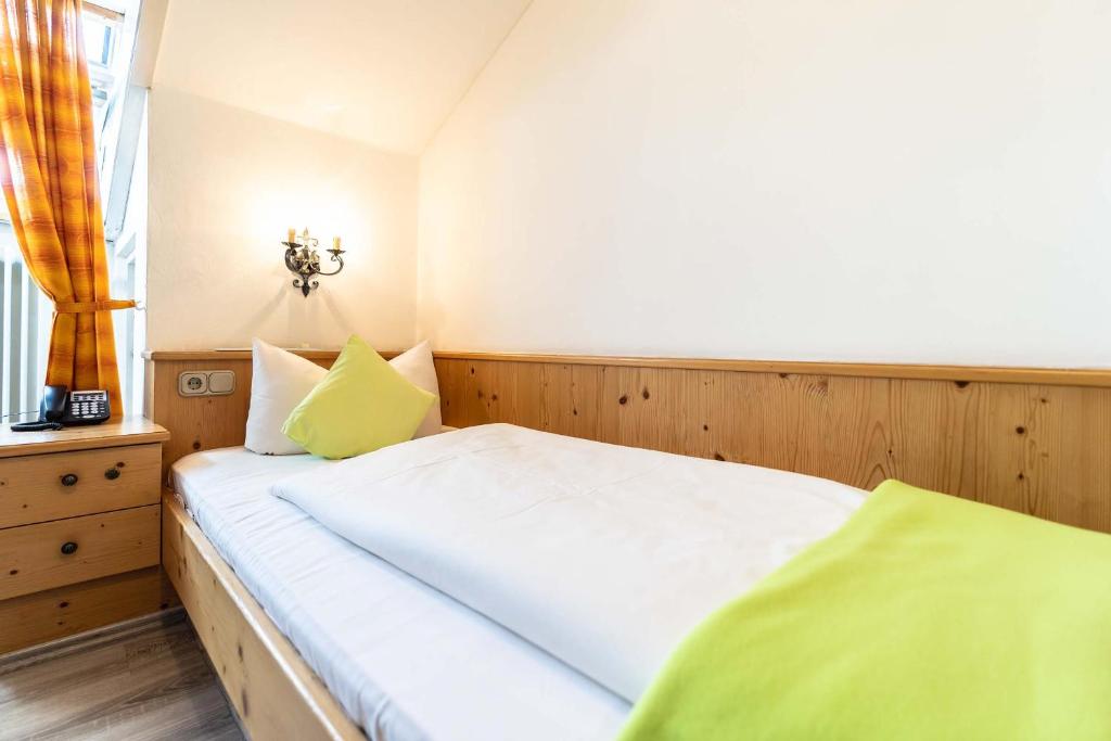 a bedroom with a white bed and a window at Hotel-Gasthof Zum Dragoner in Peiting