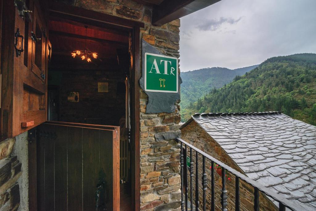 ein Schild an der Seite eines Gebäudes mit einer Tür in der Unterkunft Esquíos - Apto. Cuarto do forno in Taramundi