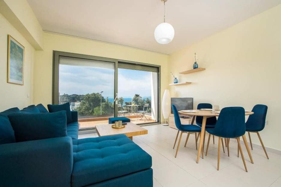 a living room with a blue couch and a table at Eden Almond Tree - Luxurious Apartment with Sea View in Rhodes Town