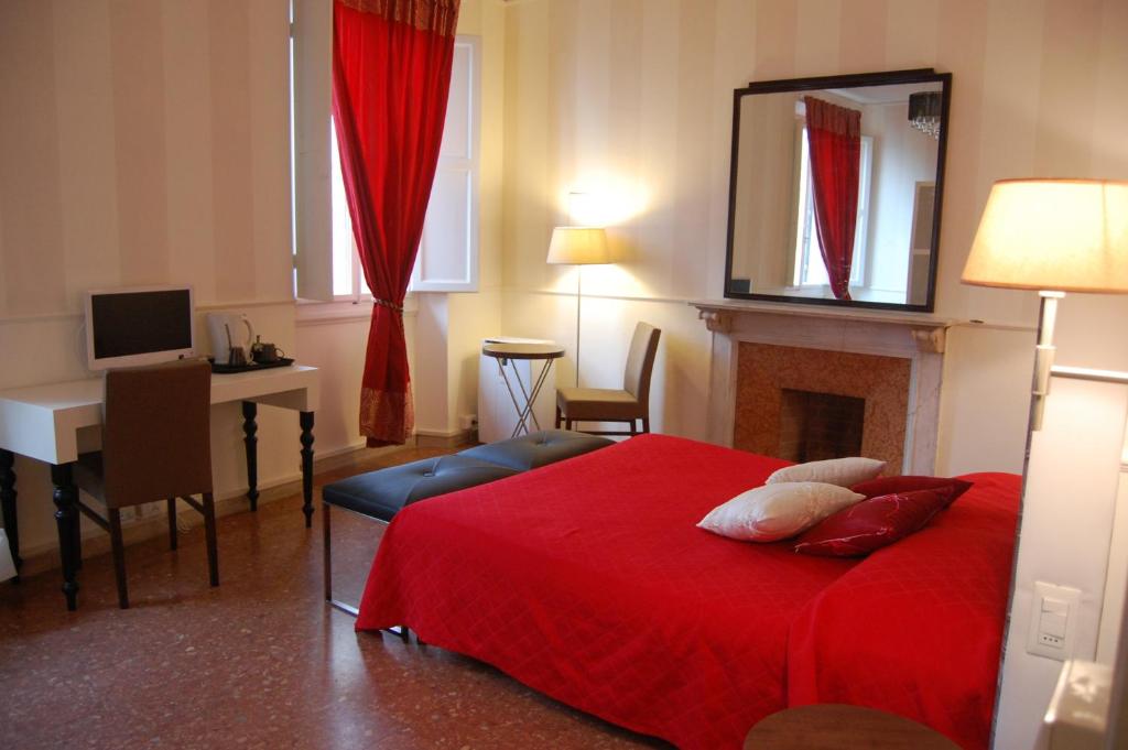 a bedroom with a red bed and a desk and a computer at Duomo View in Florence
