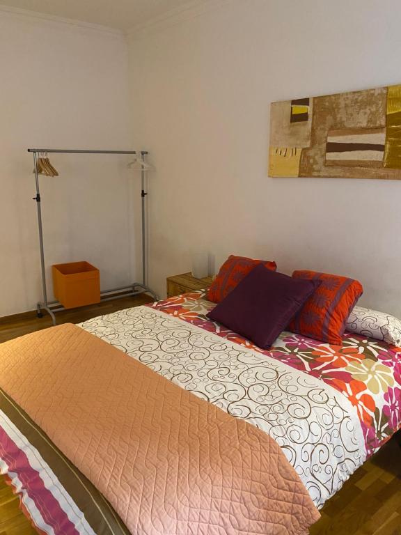 a bed with colorful pillows on it in a room at GranVia Fira Apartment in Hospitalet de Llobregat