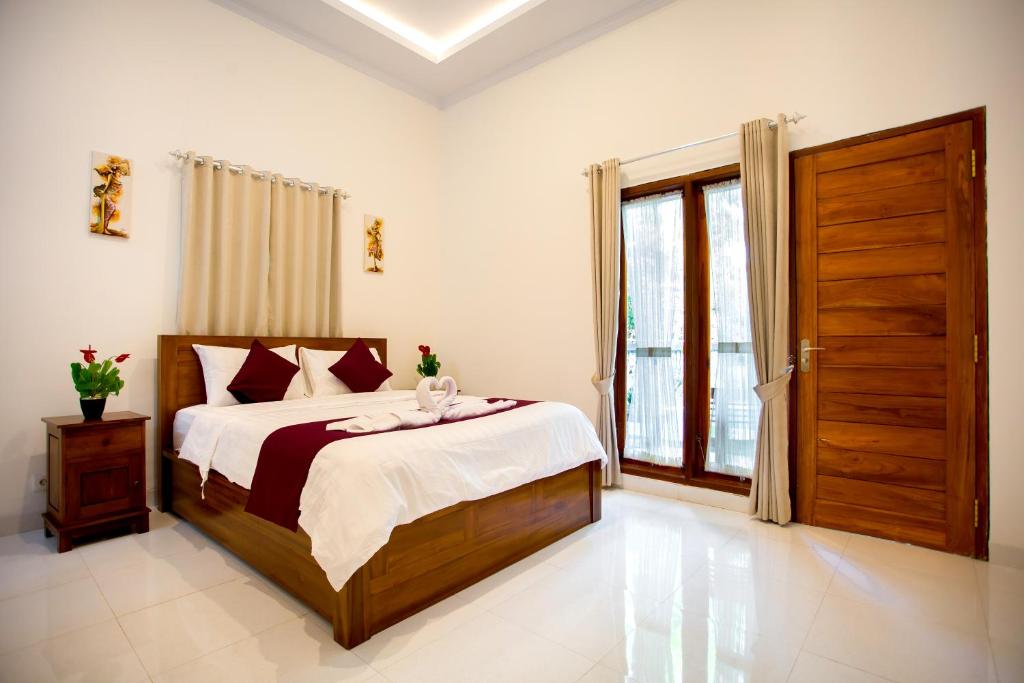 a bedroom with a bed and a large window at The Puncak Santhi Inn in Nusa Penida