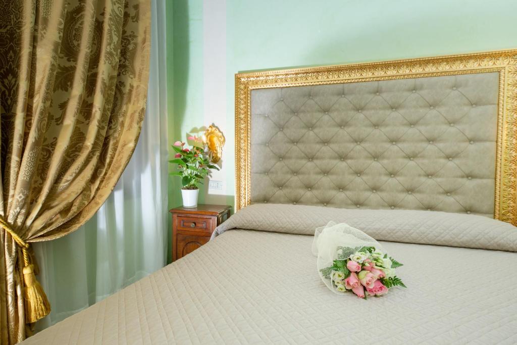 a bed with a gold frame with flowers on it at Hotel Marconi in Venice