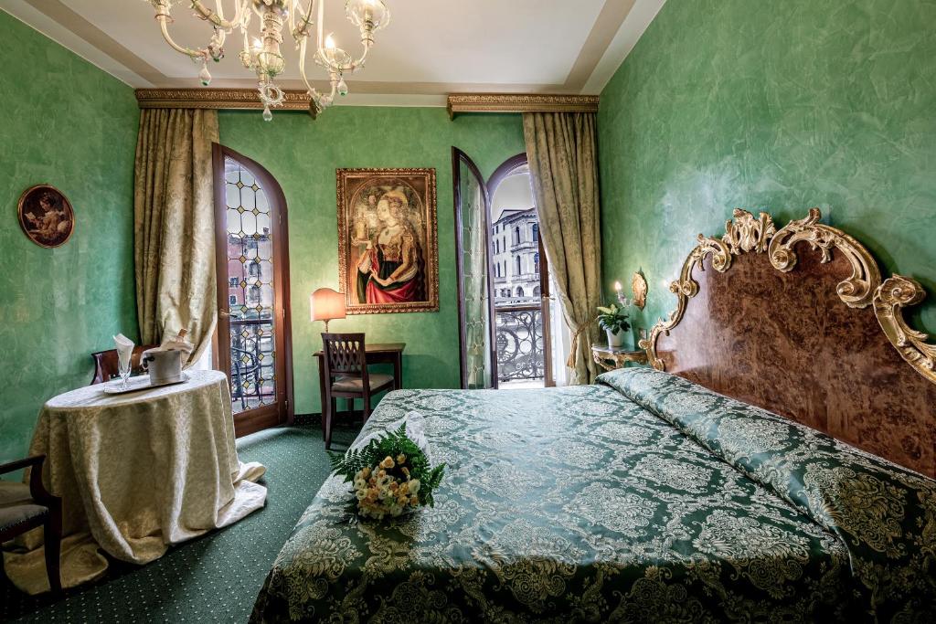 a bedroom with a bed and a table in it at Hotel Marconi in Venice