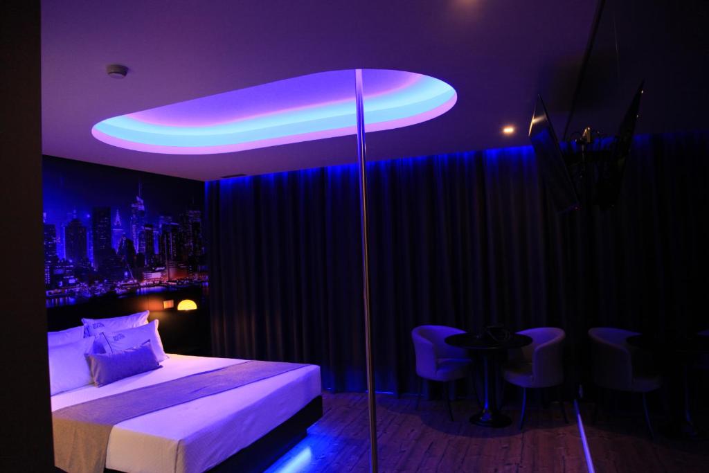1 dormitorio con cama e iluminación púrpura en Motel Eleven, en Leiria
