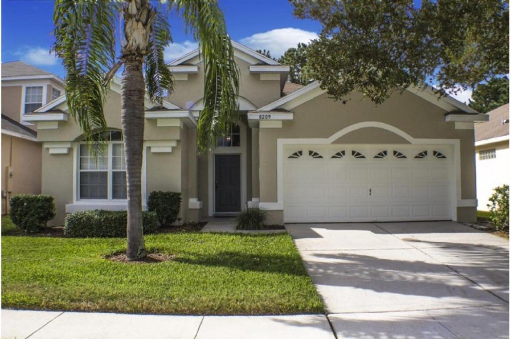 una casa con una palmera delante de ella en Three-Bedroom Pool Home Kissimmee, en Orlando