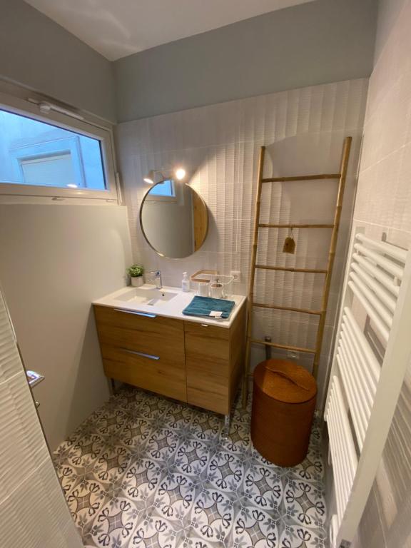 ein Bad mit einem Waschbecken und einem Spiegel in der Unterkunft Le Carnet de Sète et sa vue sur le canal in Sète