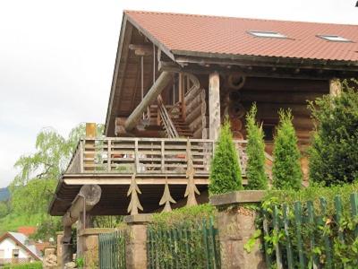a large wooden house with a porch and a fence at Blockhaus-Ferienwohnung in Oppenau