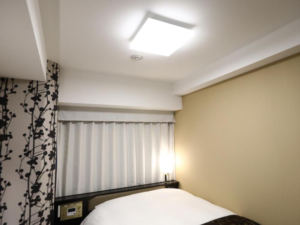 Postel nebo postele na pokoji v ubytování APA Hotel Takaoka Ekimae