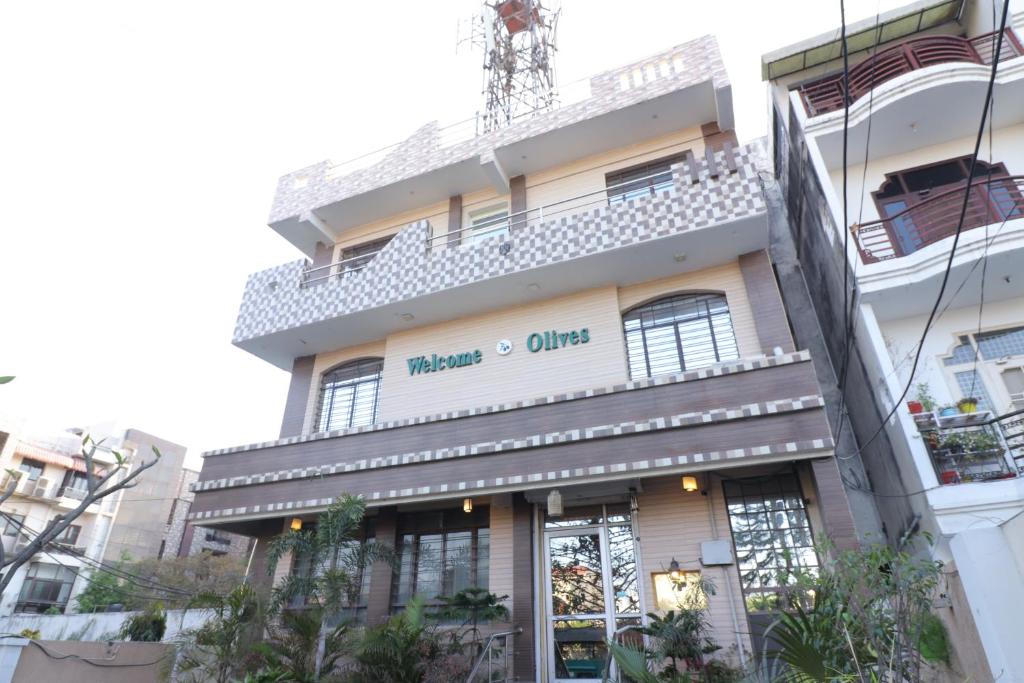 un edificio con un cartel en el costado en Welcome Olives, en Meerut