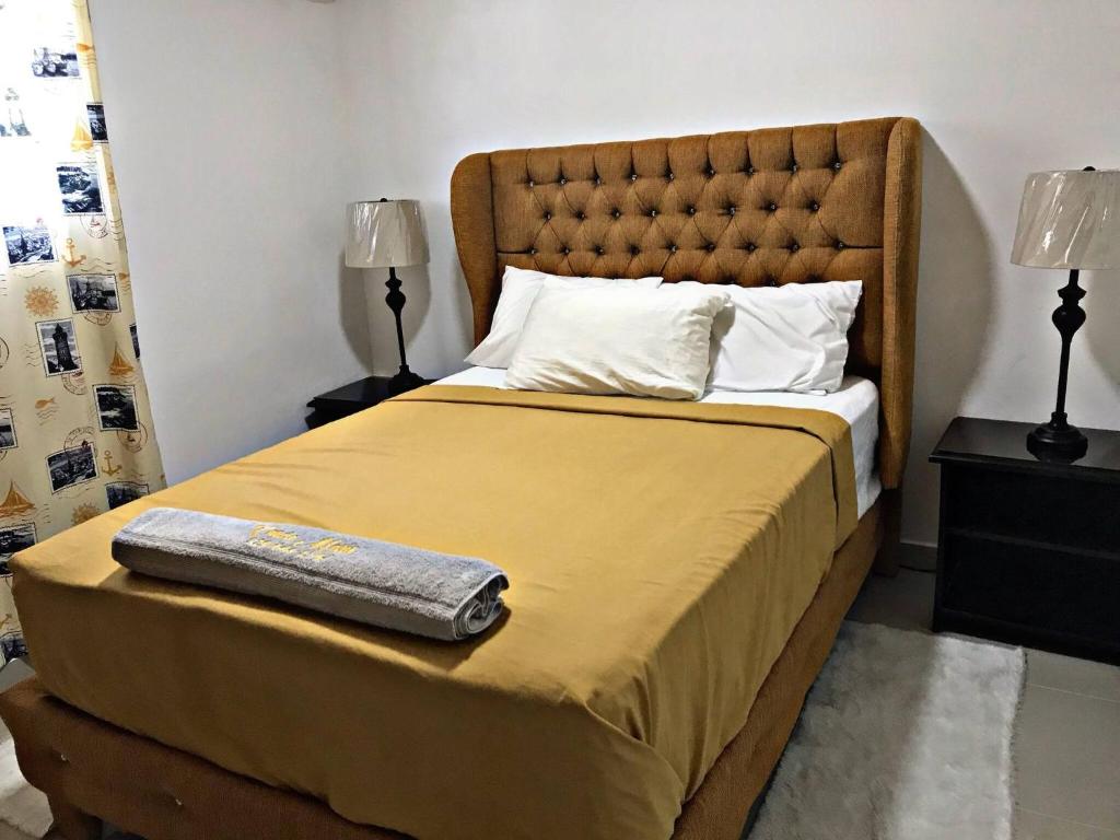 a bedroom with a bed with a yellow blanket and two lamps at Charming 1b Apto Walk To The Beaches & Main Street in Sosúa