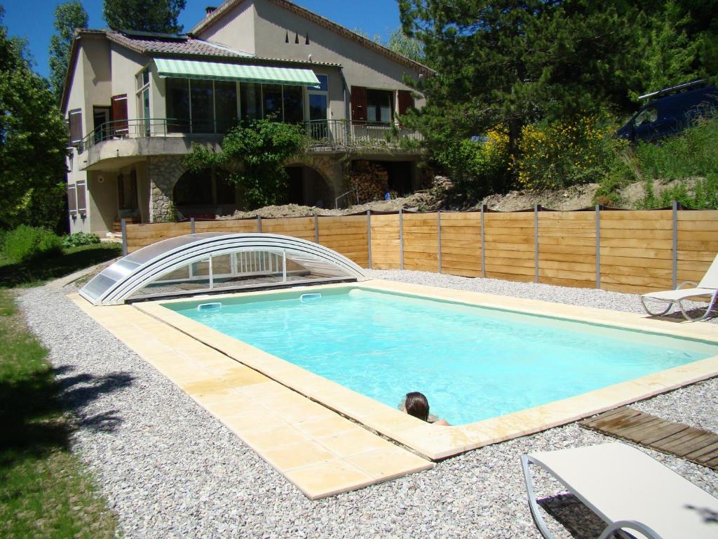 a man laying in a swimming pool in front of a house at Gite Barbier in Die