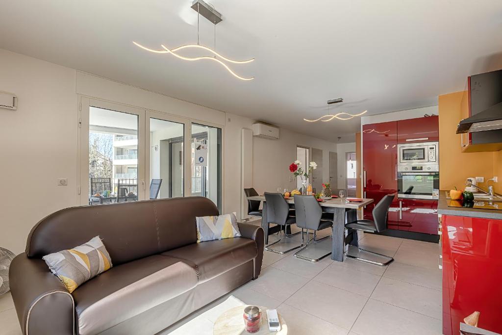 un salon et une cuisine avec un canapé et une table dans l'établissement LE LYRIQUE, à Annecy