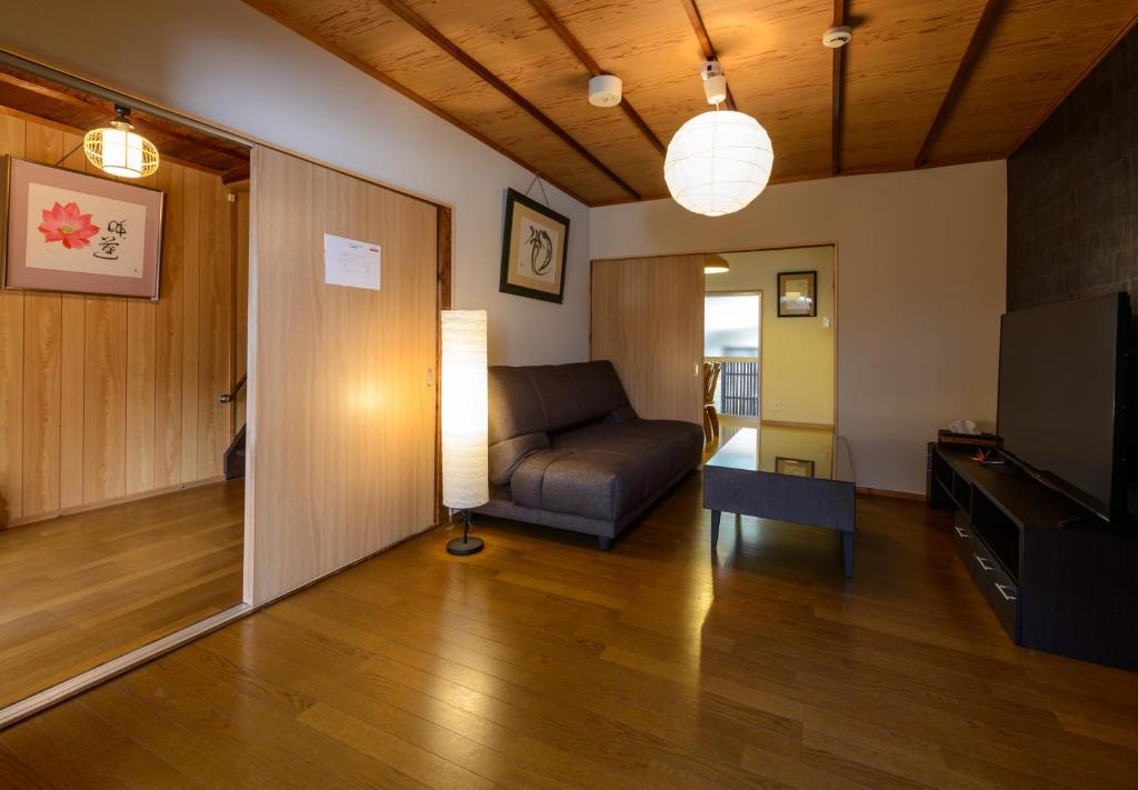 sala de estar con sofá y TV en Shiki Homes HIKARI en Kioto