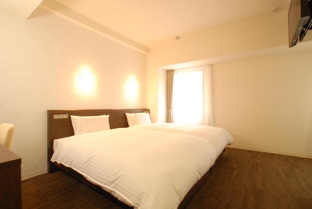 Postel nebo postele na pokoji v ubytování AB Hotel Iwata