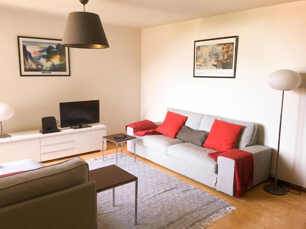 un soggiorno con divano e TV di The River's Whisper Apartment a Geres