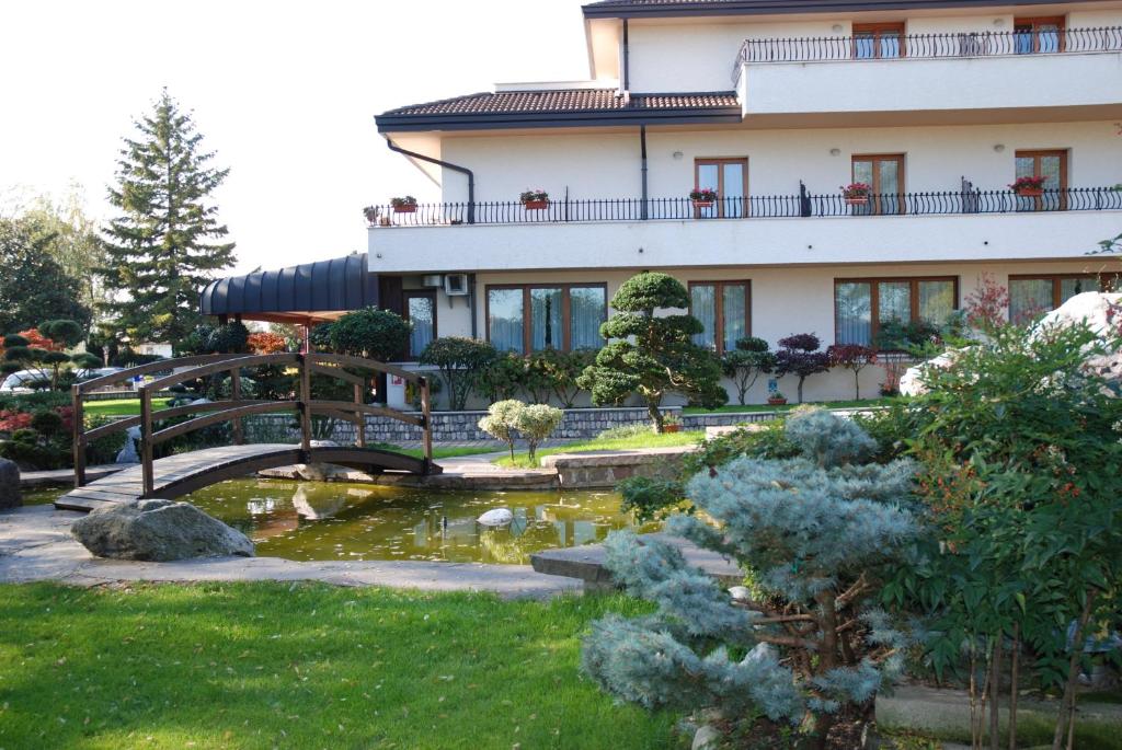 a building with a bridge over a pond in a garden at Al Giardino in Fanna