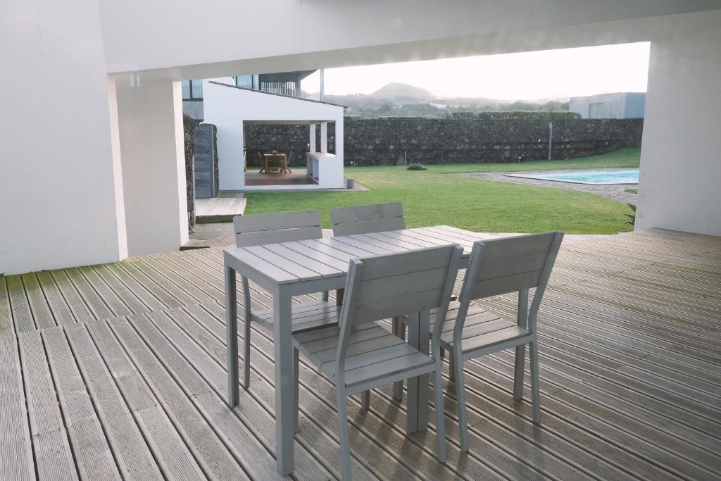 a wooden table and chairs on a wooden deck at Sao Vicente Lodge - Atlantic Retreat in São Vicente Ferreira